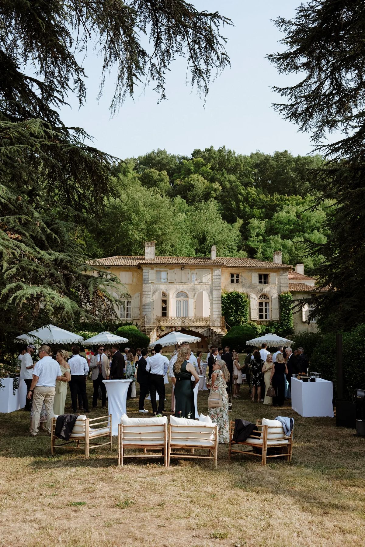 Cocktail hour on the lawn with white parasols and low seating