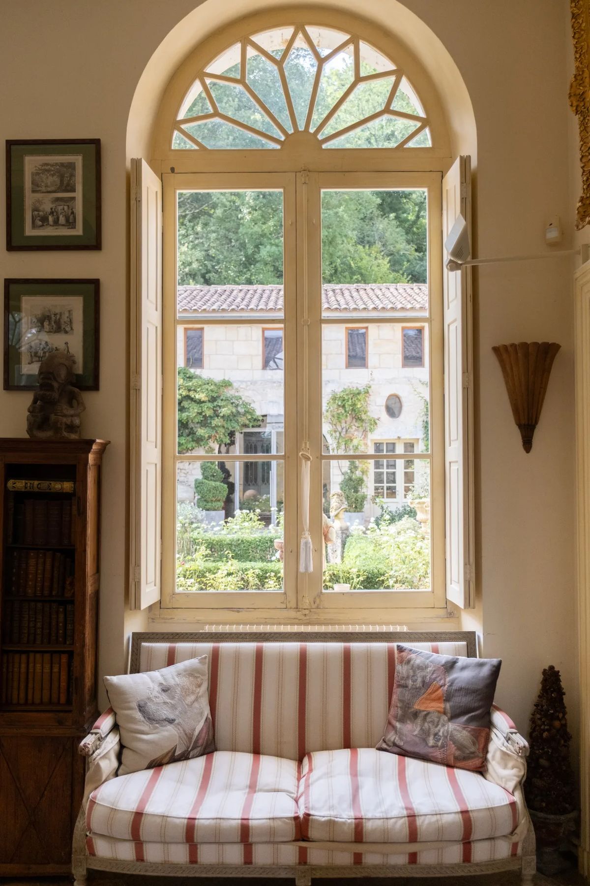 Salon window seat with striped cushions looking out over the courtyard