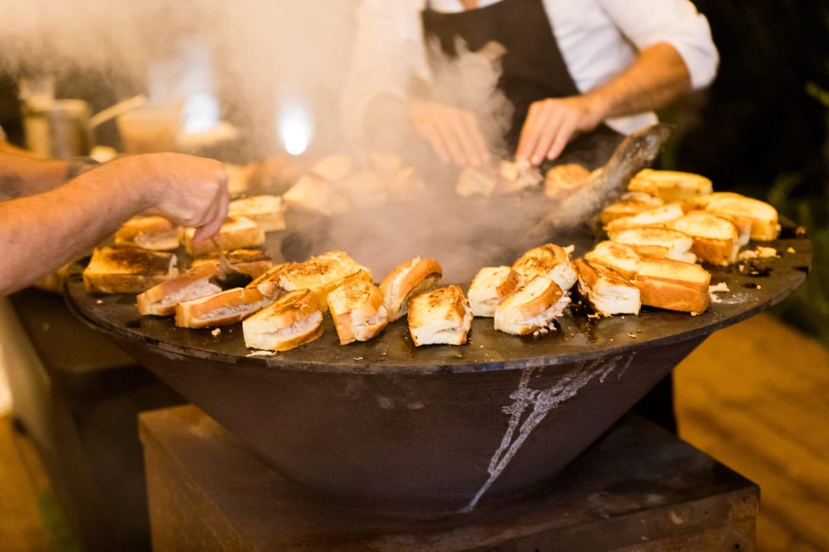 Chef cooking over an open plancha at Les Oliviers de Palombaggia