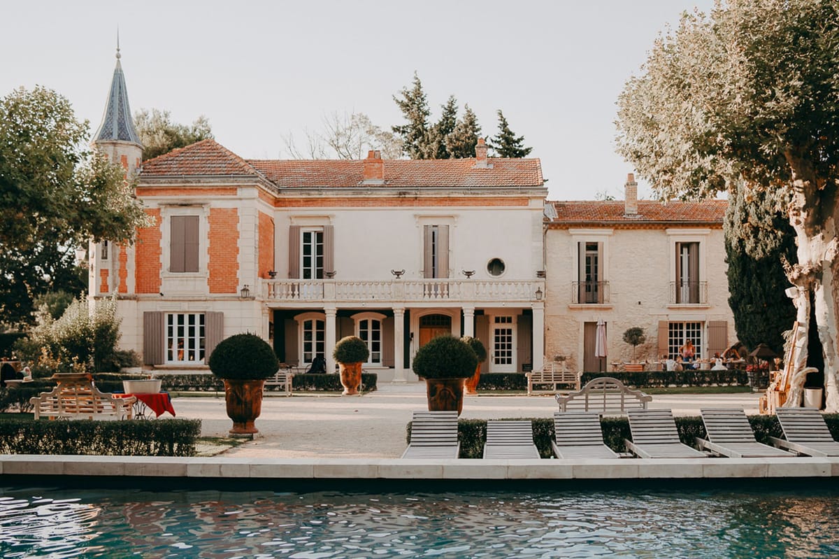 Mas D'Arvieux Provencal farmhouse exterior with turret, pool and sun loungers in Tarascon