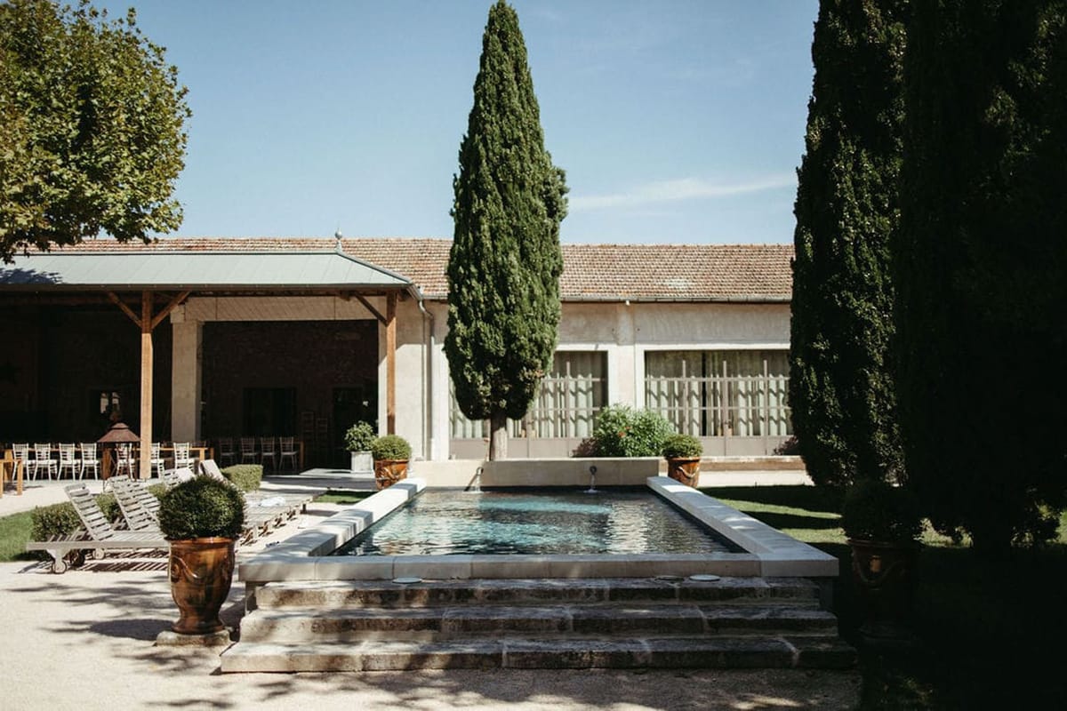 Mas D'Arvieux courtyard pool area with cypress trees and covered dining pavilion in Provence