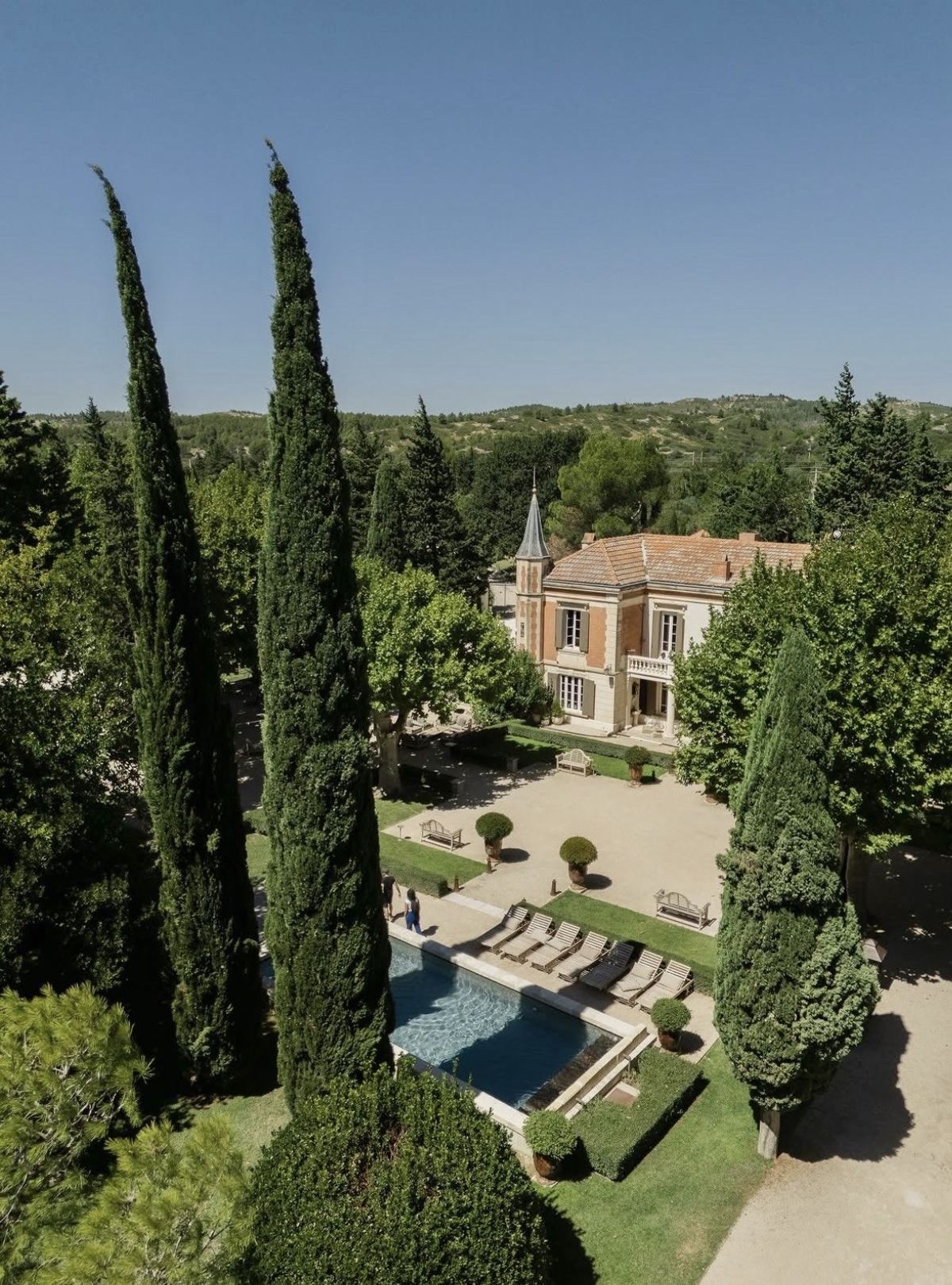 Mas D'Arvieux aerial view showing Provencal farmhouse with turret, swimming pool, and cypress trees in Alpilles