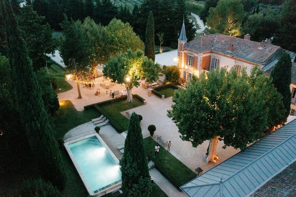 Aerial dusk view of Mas D'Arvieux chateau, pool and gardens in Provence