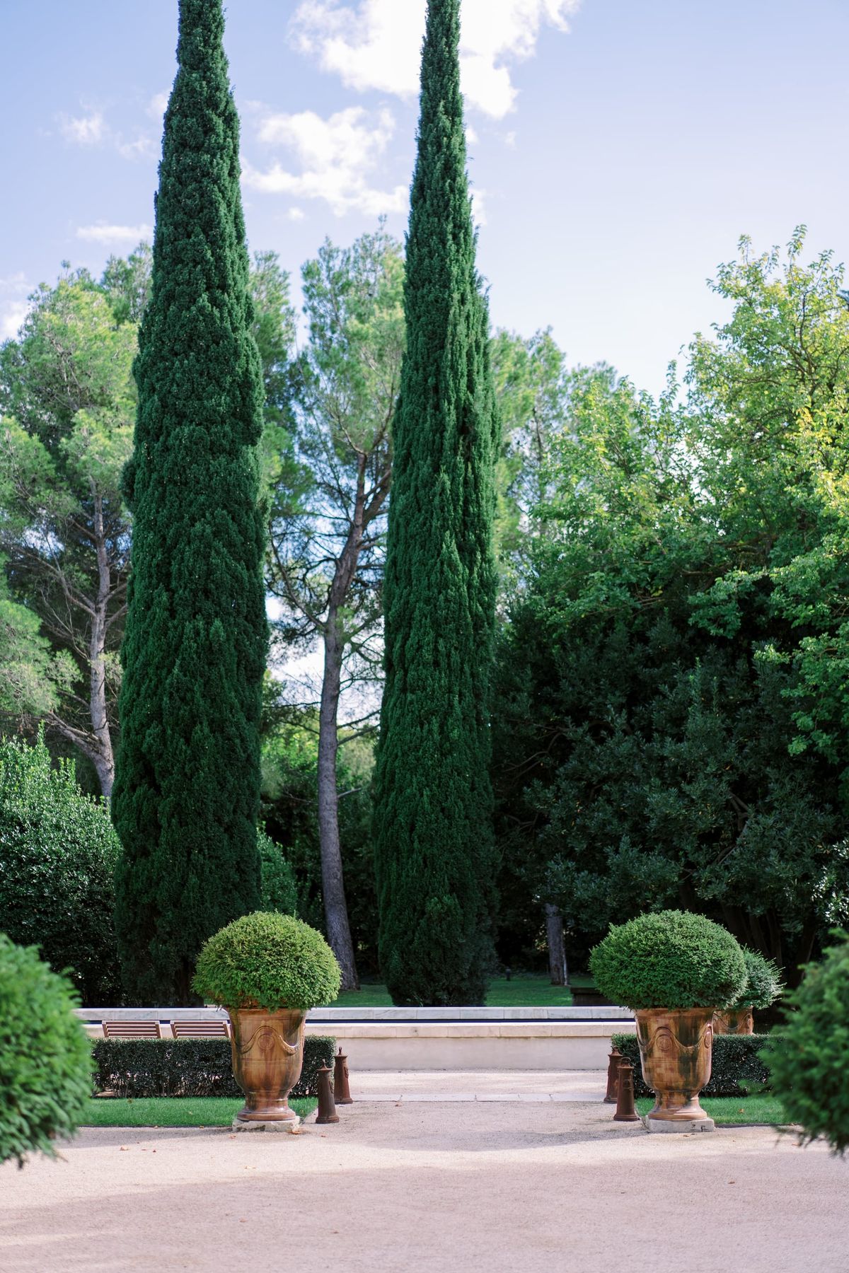 Mas D'Arvieux stone facade with shaded terrace, parasols and olive trees