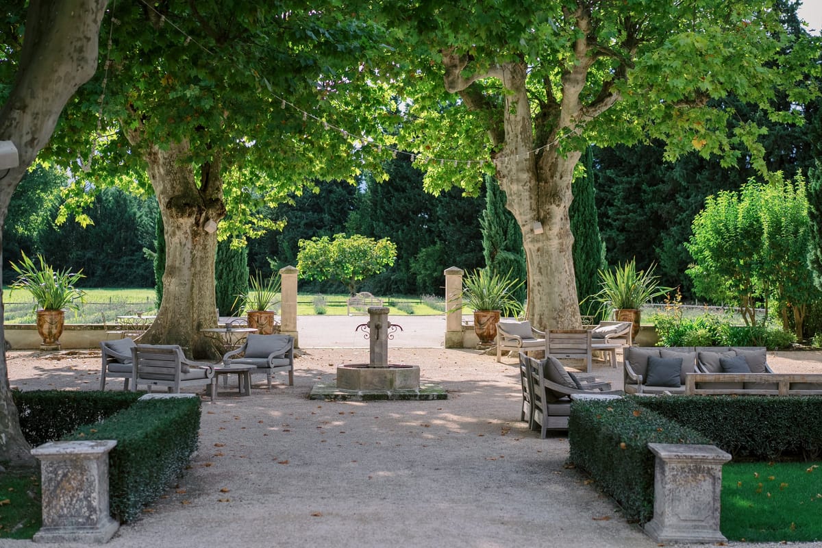 Mas D'Arvieux courtyard fountain framed by twin cypress trees and lounge seating