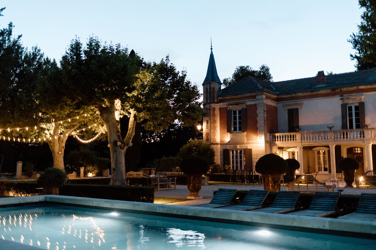 Mas D'Arvieux courtyard cocktail hour beneath a fairy-lit plane tree at dusk