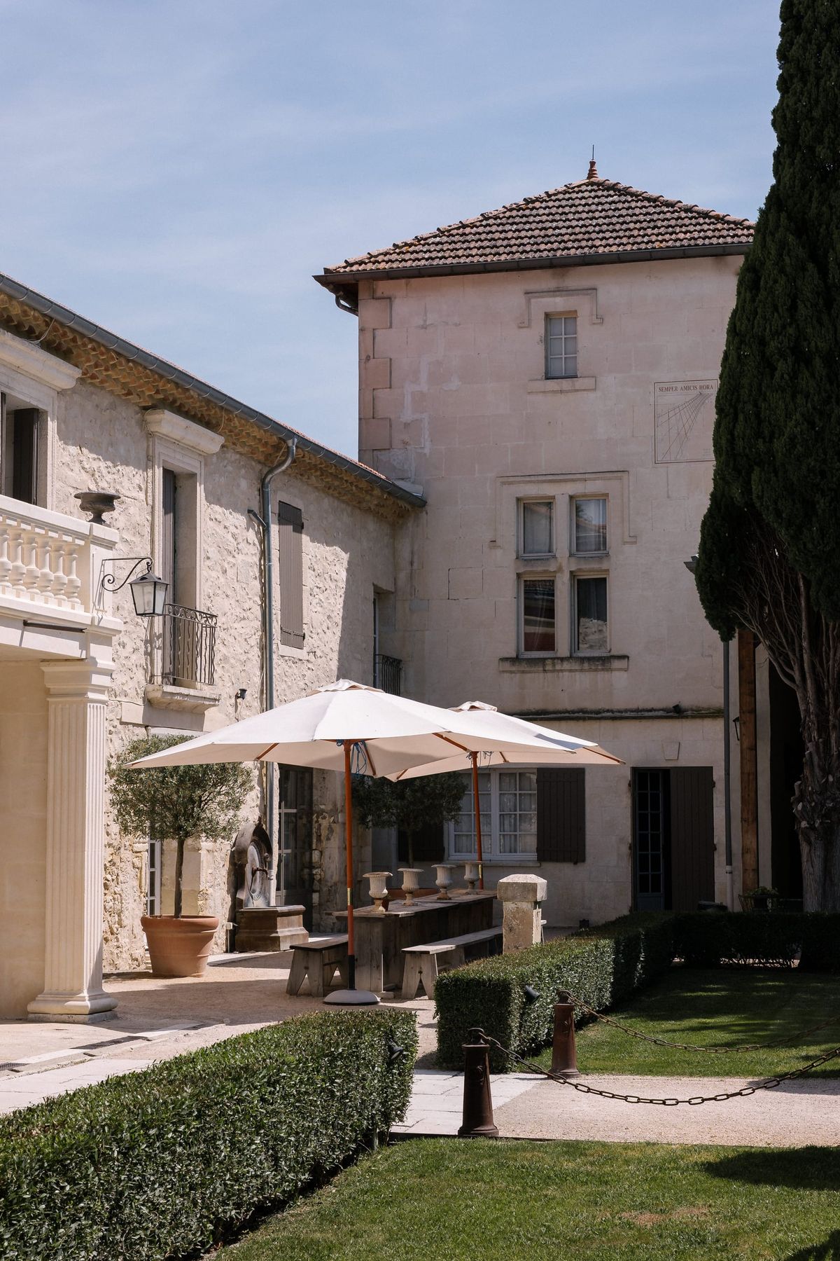 Mas D'Arvieux outbuilding courtyard set with a long table and parasols