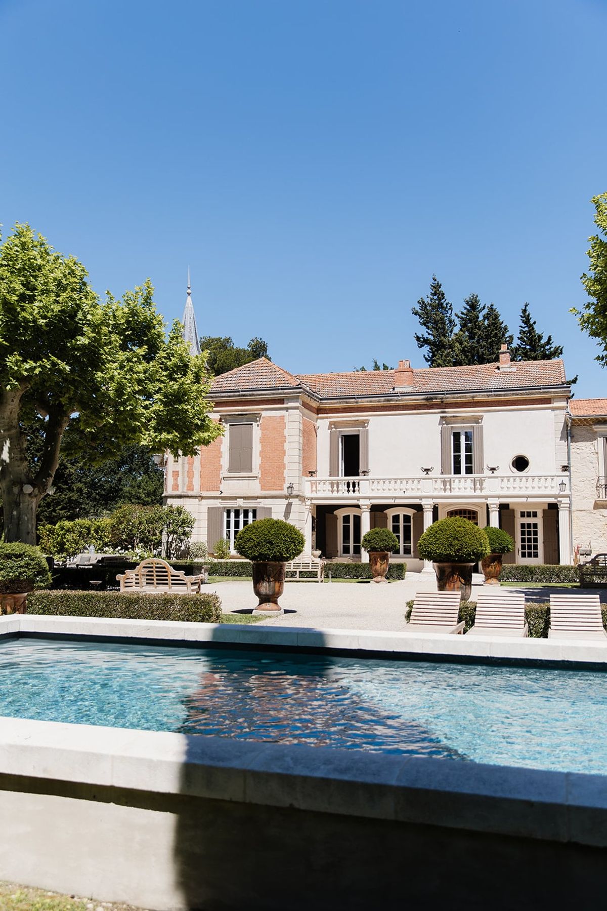 Mas D'Arvieux chateau facade with garden bench and terracotta urns