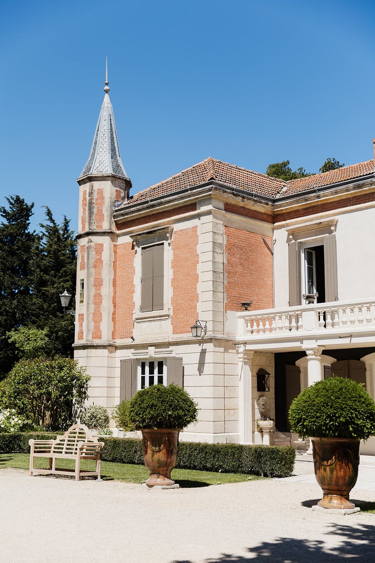 Mas D'Arvieux chateau facade and turret with garden urns in daylight