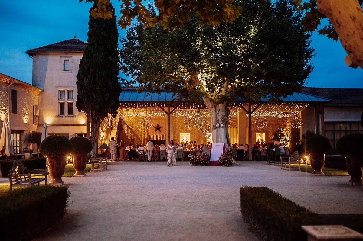 Mas D'Arvieux reception dinner beneath a fairy-lit plane tree at dusk