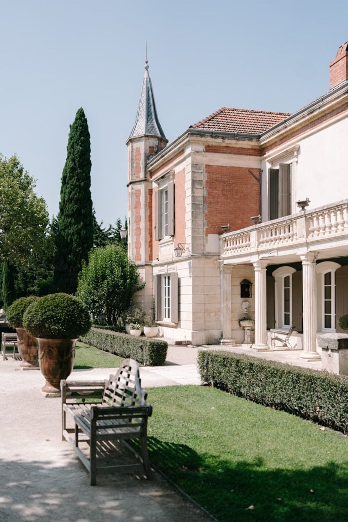 Mas D'Arvieux chateau facade and turret with garden bench and urns