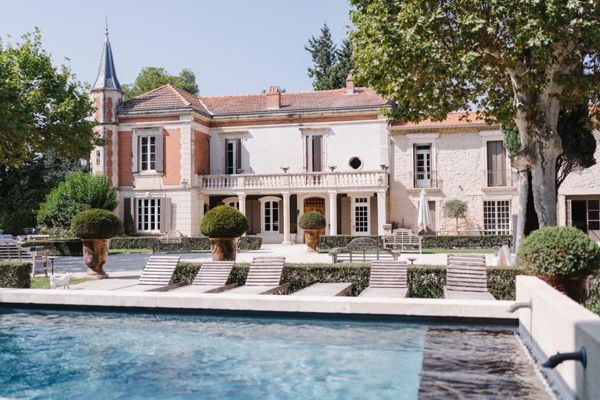 Mas D'Arvieux swimming pool and chateau facade with terracotta urns