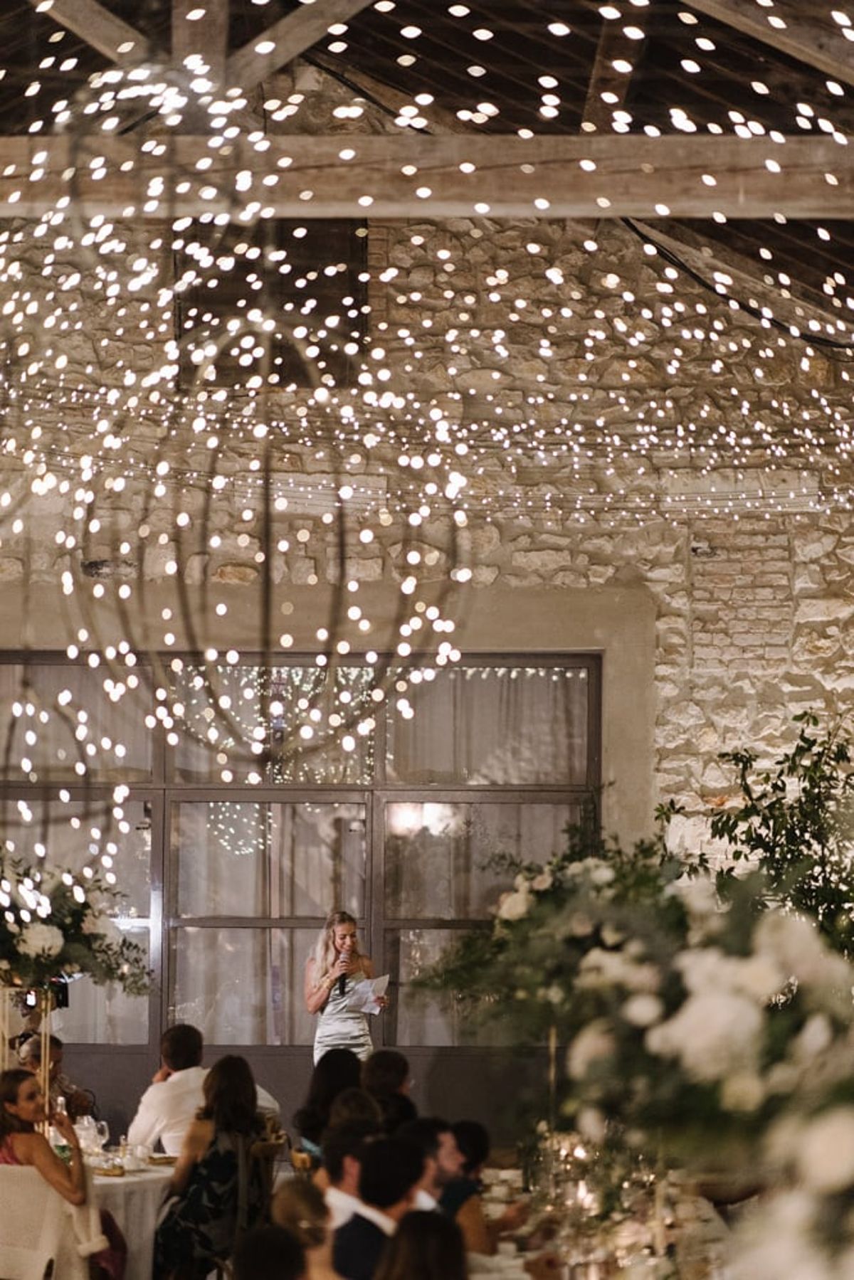 Mas D'Arvieux reception speeches beneath string lights in the stone barn