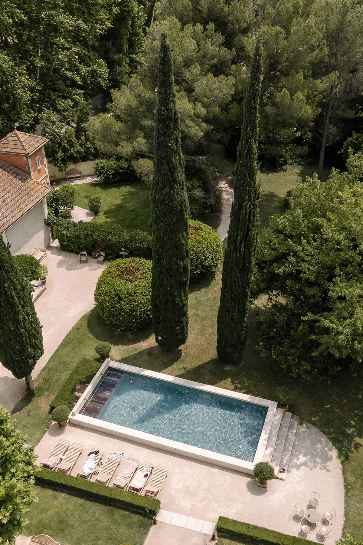 Aerial view of Mas D'Arvieux pool framed by cypress and garden pathways