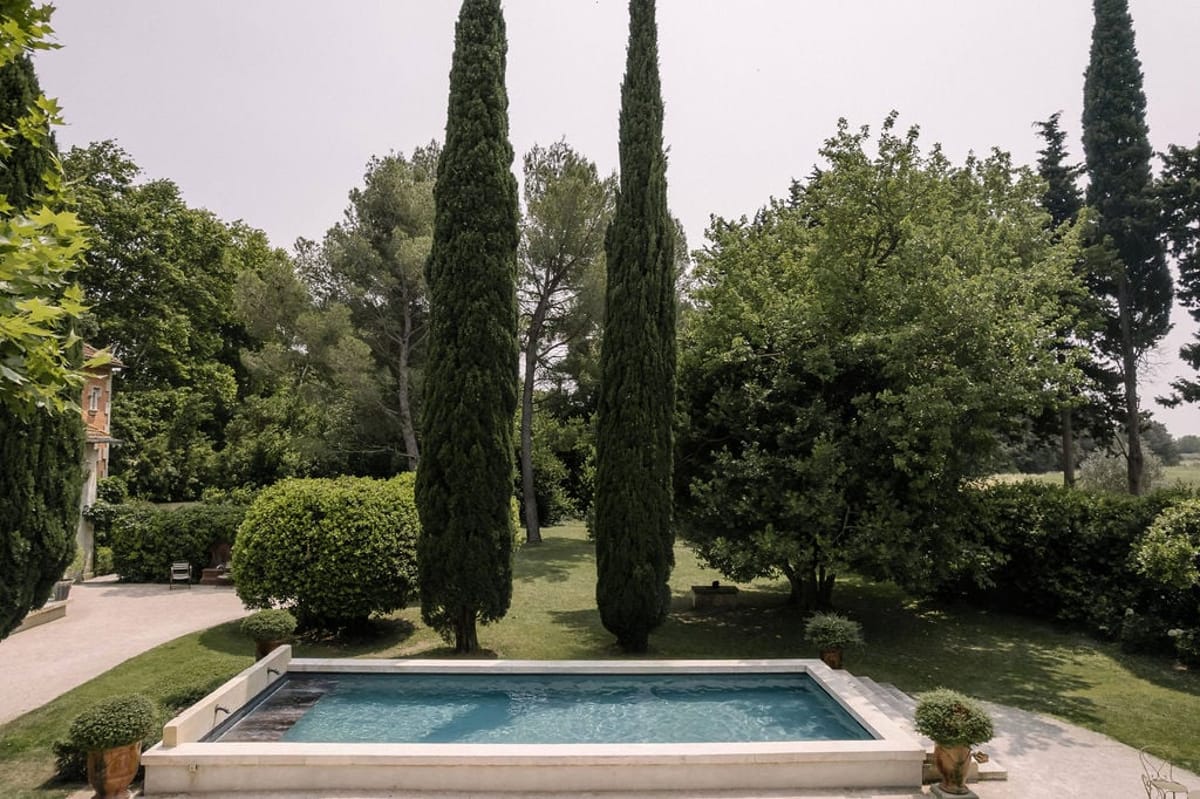 Mas D'Arvieux swimming pool framed by tall cypress trees