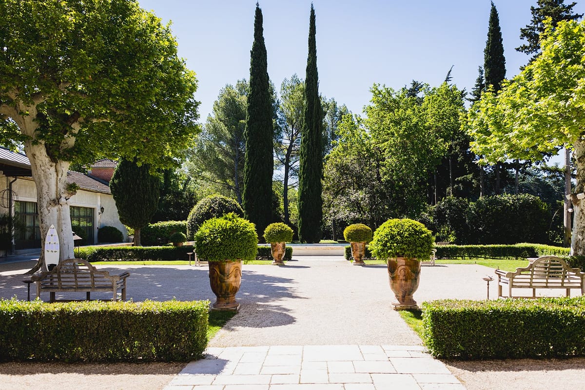 Mas D'Arvieux garden courtyard lined with terracotta urns and cypress trees