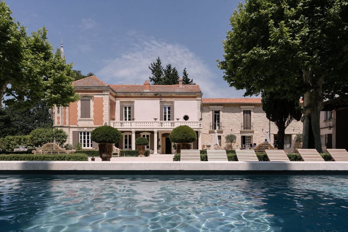 Mas D'Arvieux chateau facade and pool seen across the gardens