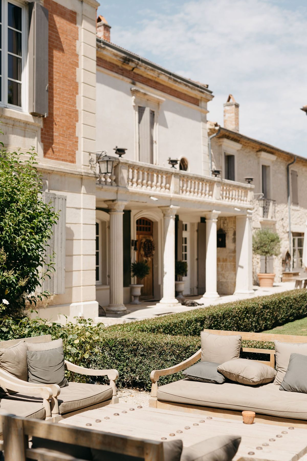 Mas D'Arvieux courtyard terrace with lounge seating facing the chateau colonnade