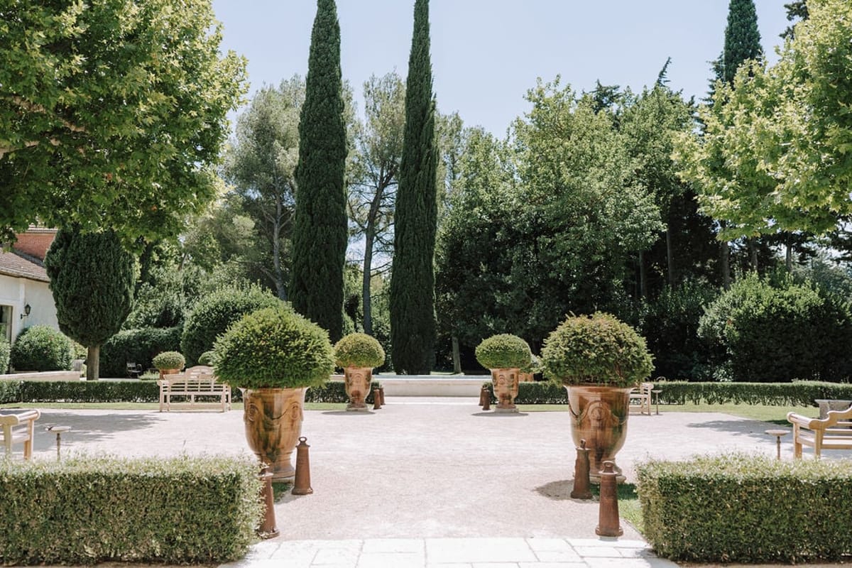 Mas D'Arvieux garden courtyard with terracotta urns and cypress trees