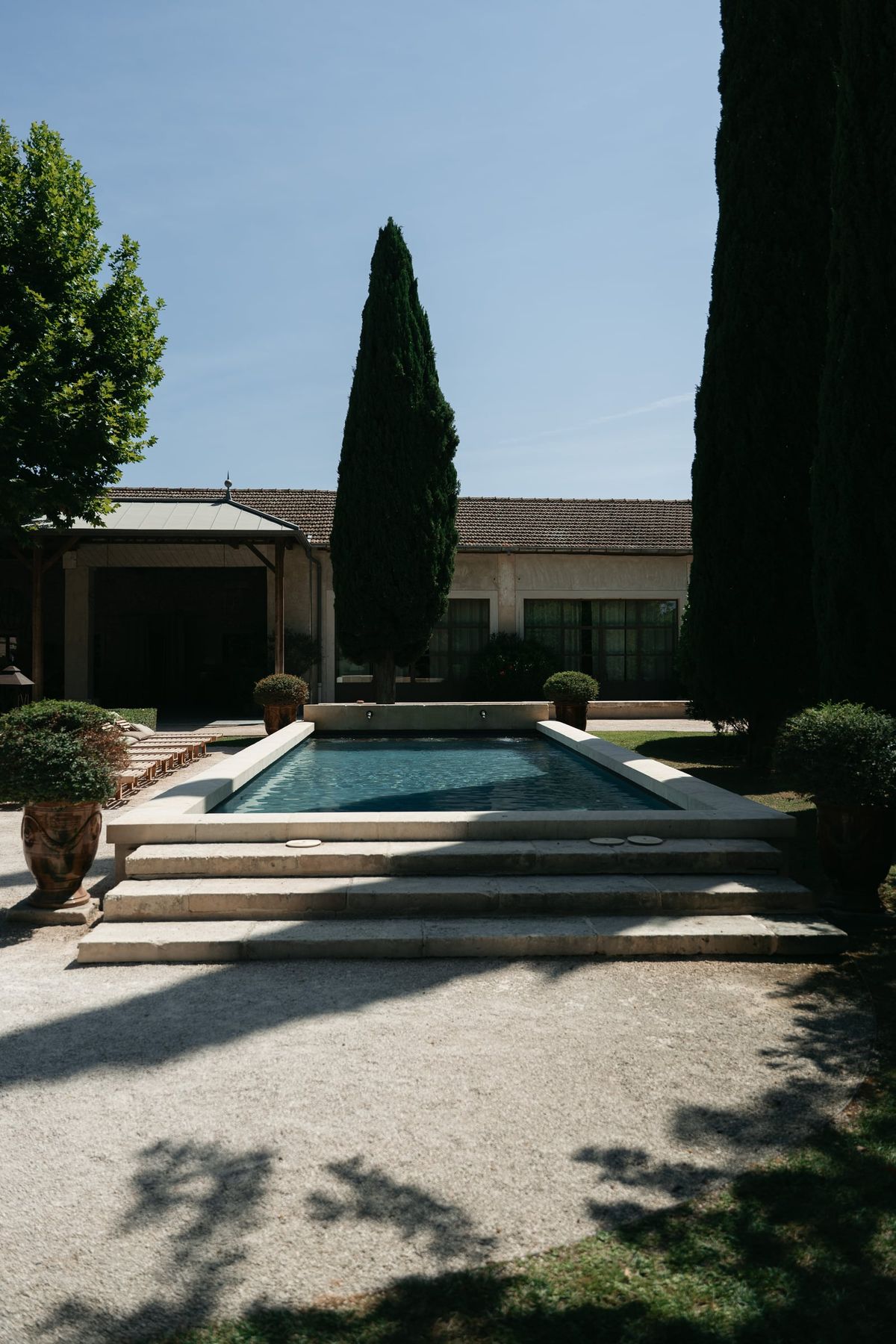 Mas D'Arvieux swimming pool and chateau framed by cypress trees