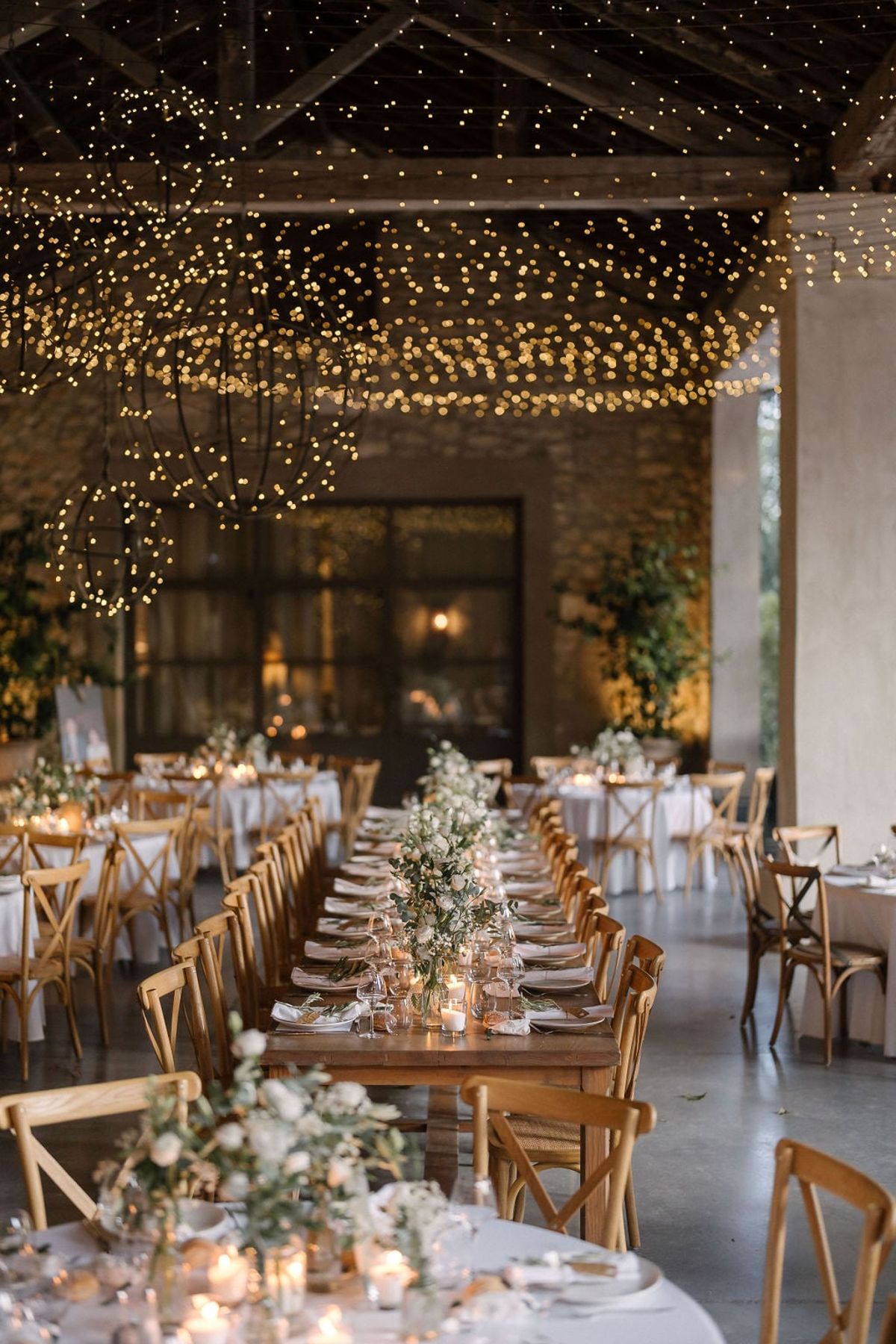 Mas D'Arvieux stone barn reception tables lit with string lights and candles