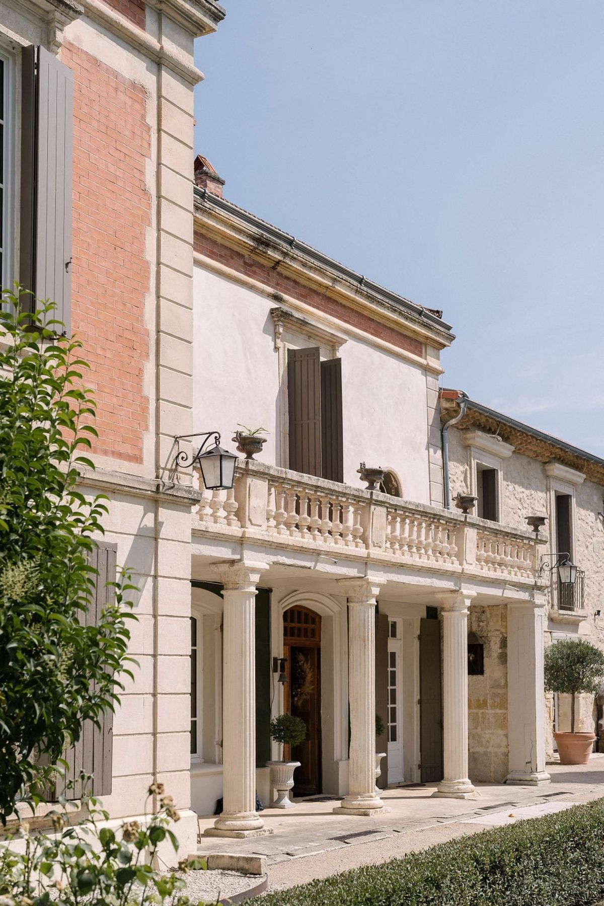 Mas D'Arvieux swimming pool and chateau facade framed by cypress trees