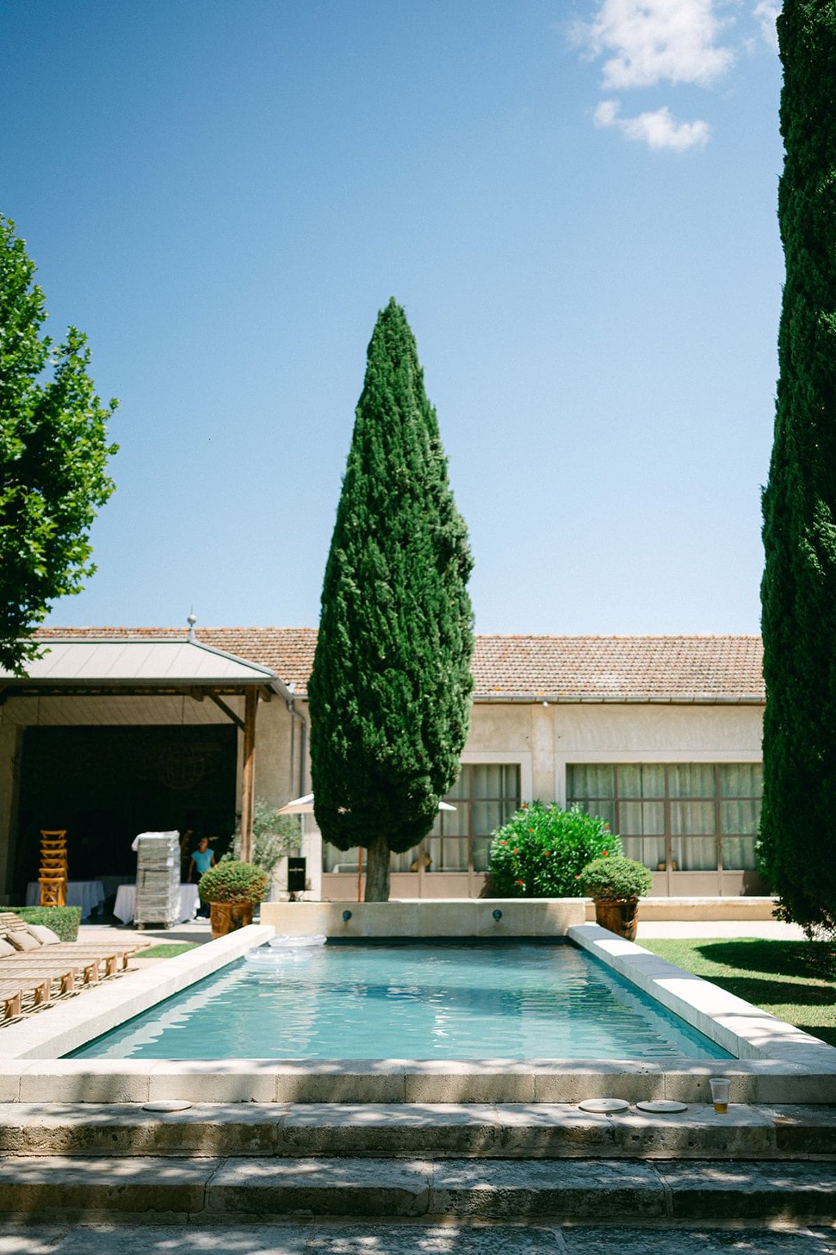 Mas D'Arvieux swimming pool and outbuilding framed by a single cypress tree
