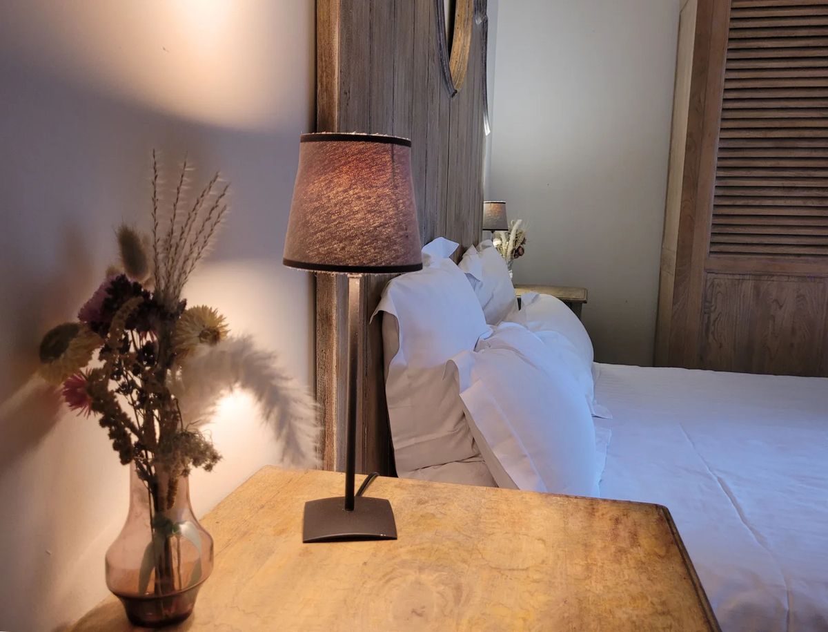 Bedside lamp and reclaimed-wood headboard detail at Domaine de Vavril