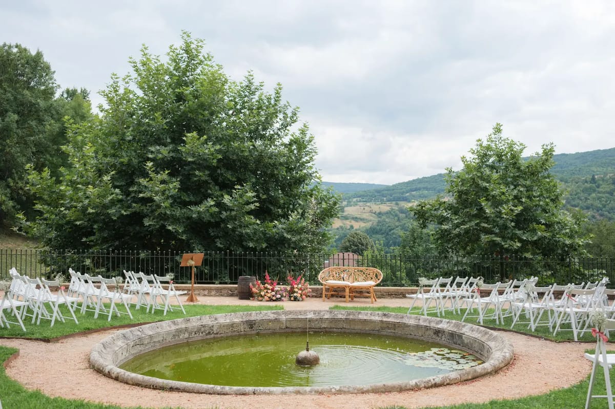 Garden wedding ceremony by the ornamental basin at Domaine de Vavril with valley views beyond the gardens