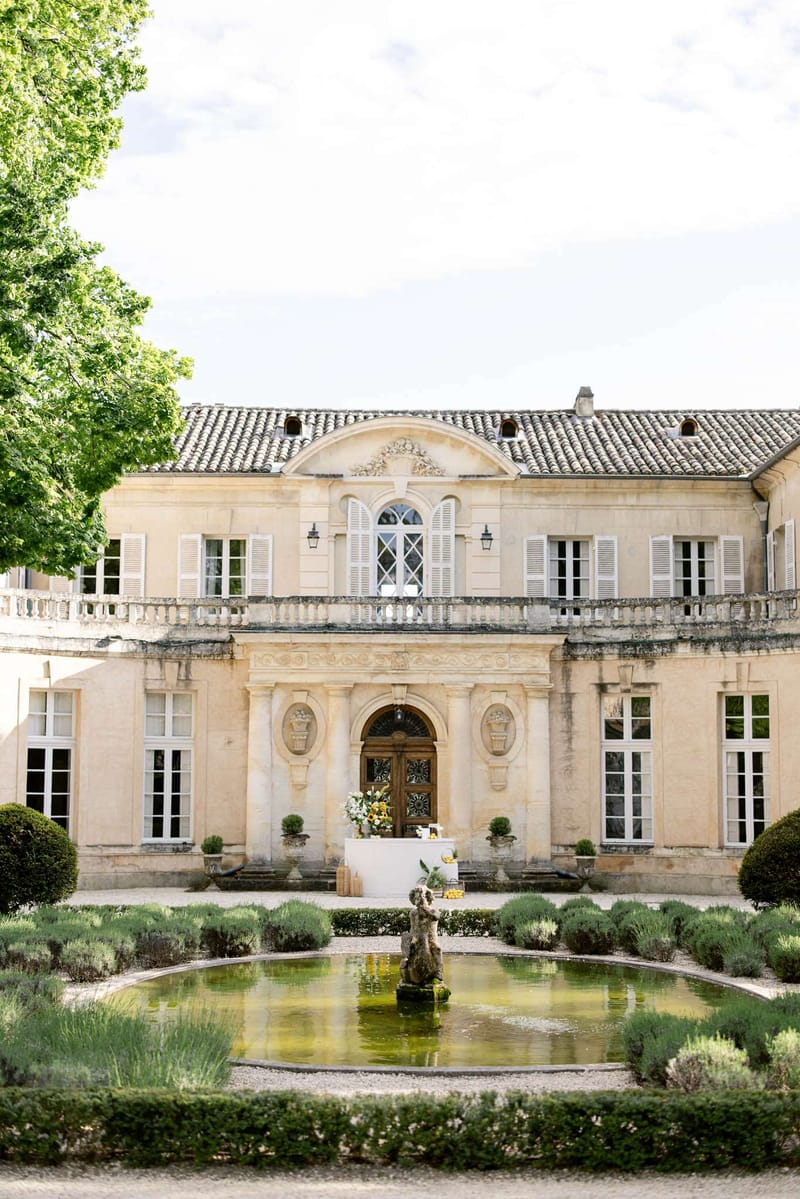 18th-century limestone chateau with ornamental pond, lavender hedges, and box topiary in formal garden