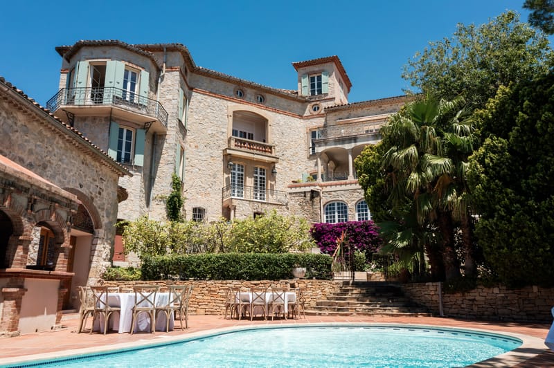 Provencal stone villa with sage shutters, bougainvillea, and circular pool with cross-back reception tables