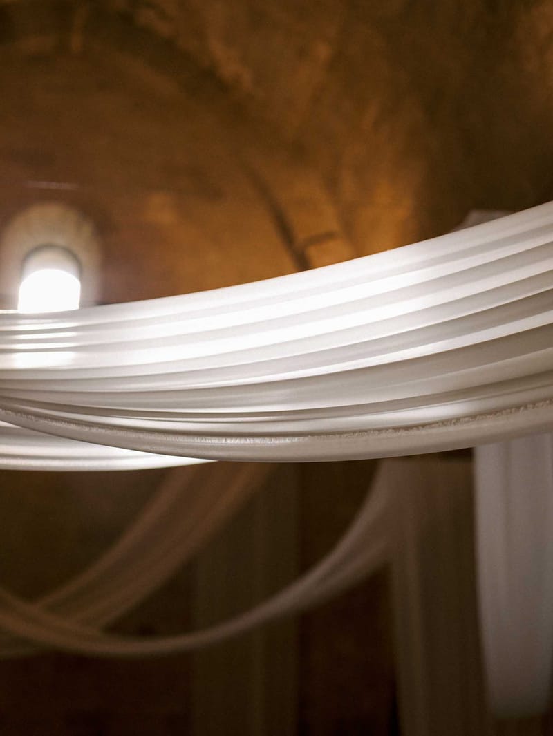 Close-up of white stone archway detail inside historic chapel with amber vaulted ceilings and arched window