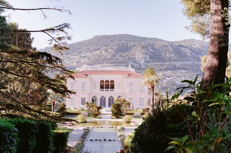 Pink Belle Epoque villa with reflecting pool, palm trees, and formal garden on the French Riviera