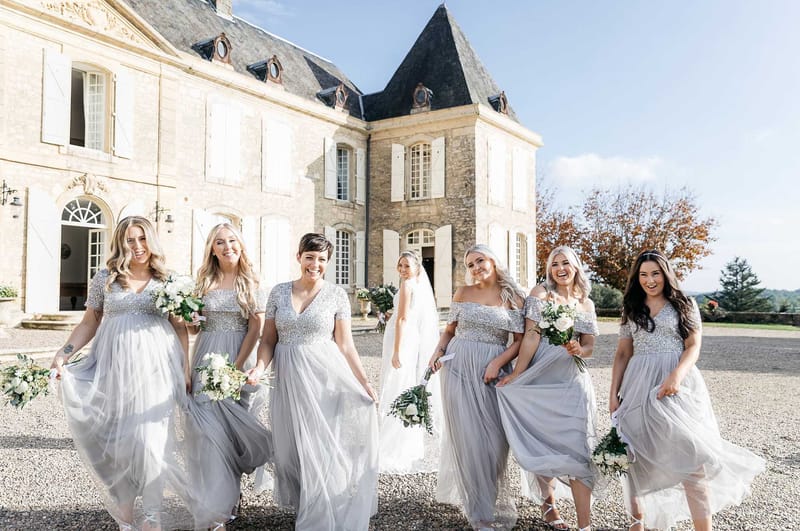 Six bridesmaids in silver-grey sequined tulle gowns walking toward camera with bride behind