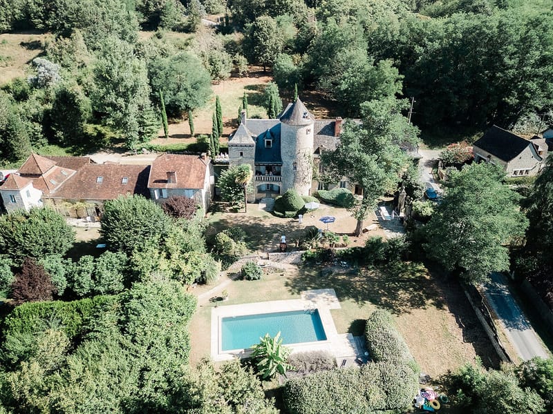 Aerial view of French château wedding venue with swimming pool and landscaped grounds