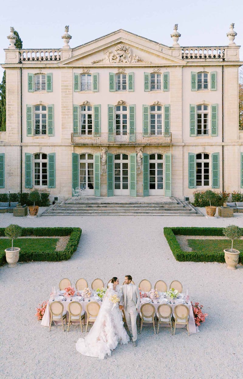 Aerial view of intimate reception setup in château courtyard with neoclassical French architecture