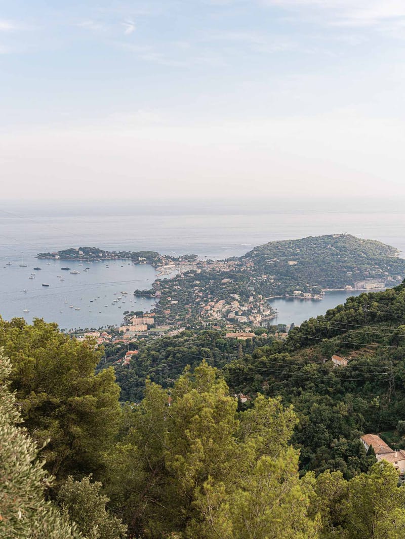 Aerial view of Mediterranean coastal wedding venue with forested hills and marina