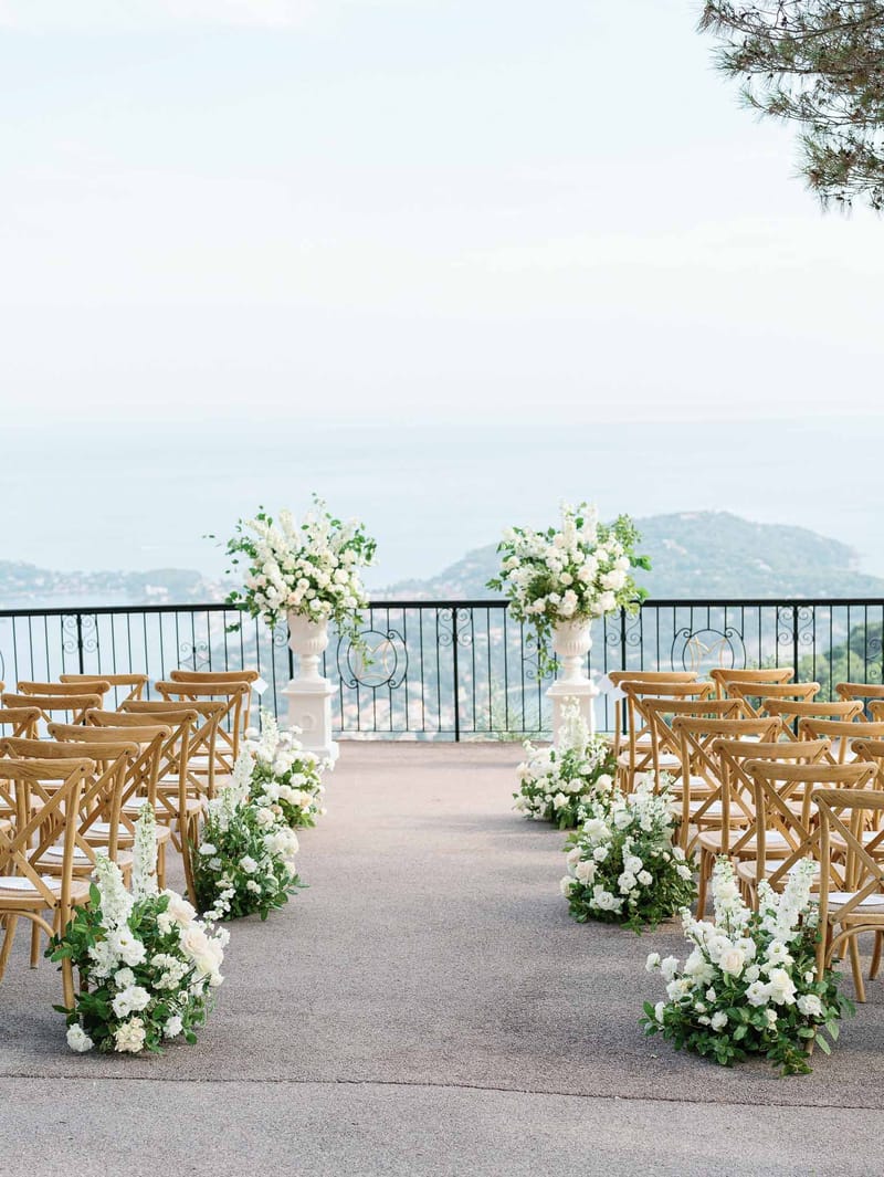 Outdoor ceremony setup with crossback chairs on elevated terrace overlooking rolling hills