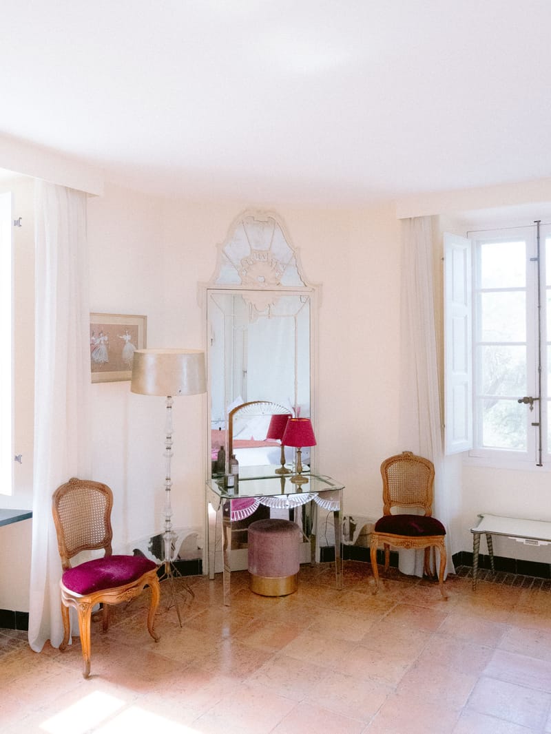 Bridal suite with gilt Louis XV chairs, Venetian mirror, magenta velvet accents, and crystal floor lamp
