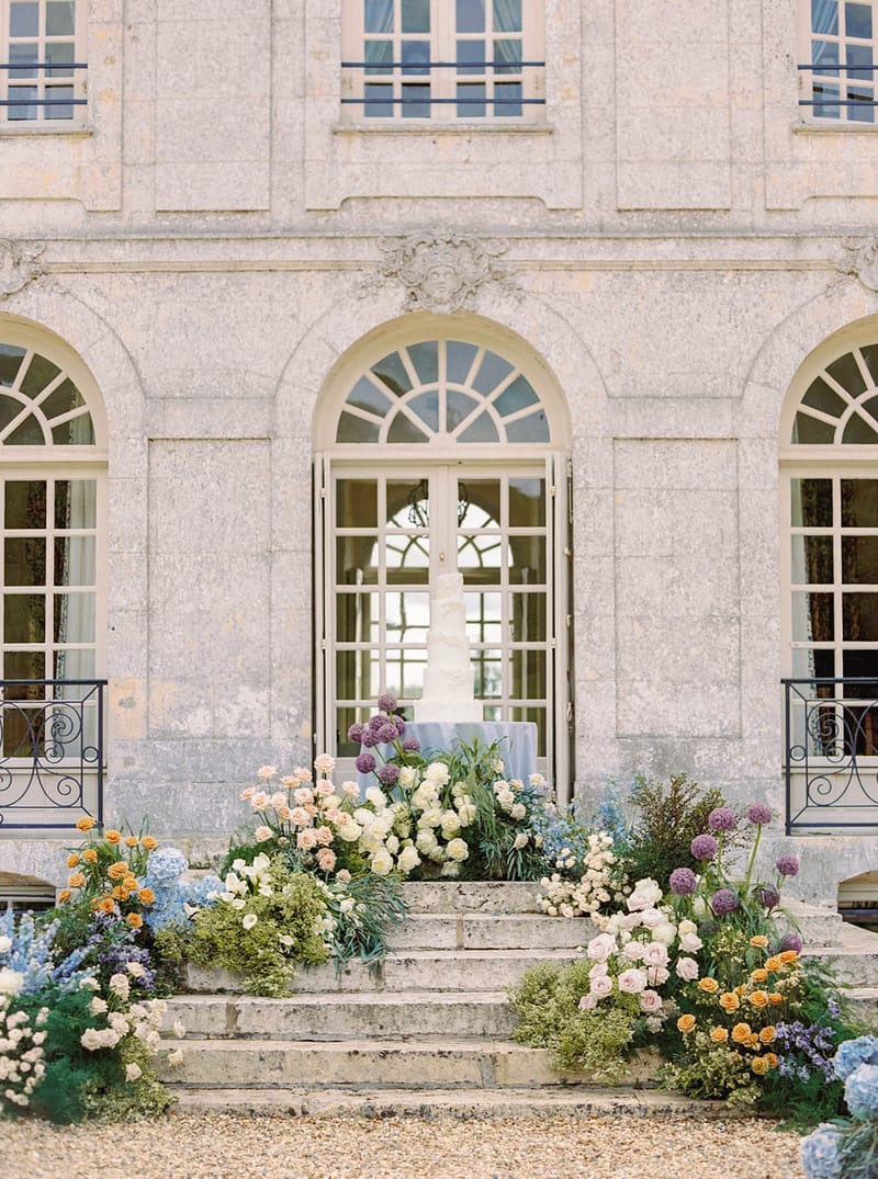 French château stone façade with floral ceremony entrance decoration at historic wedding venue