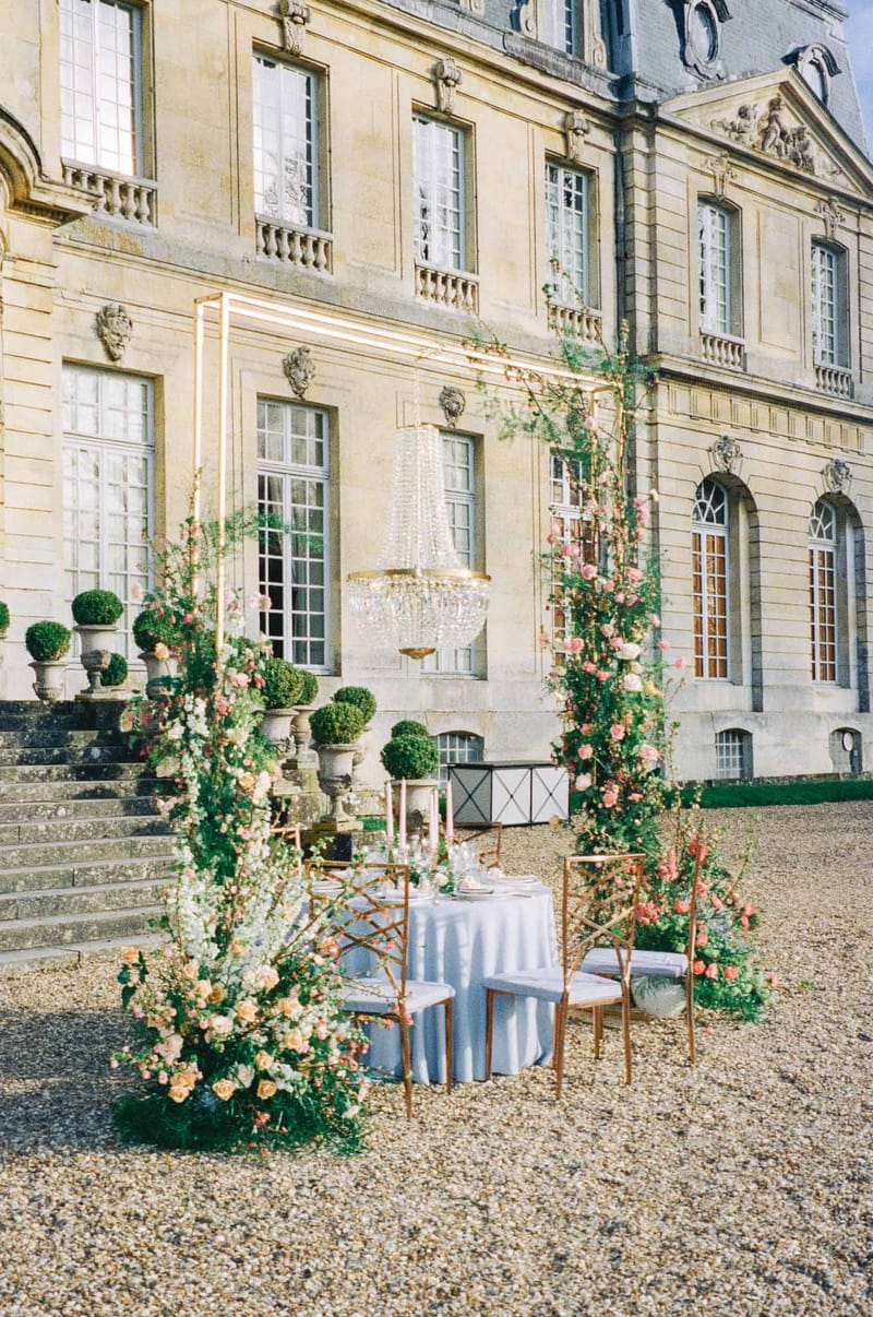 Intimate courtyard seating with floral trellises at French château wedding venue