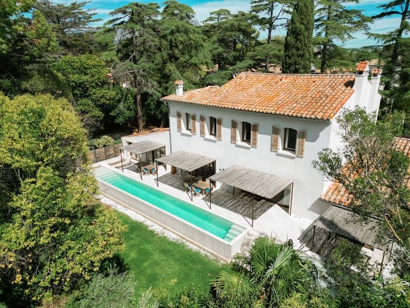 Aerial close-up of farmhouse with pool, loungers, and dining terrace at Domaine Rocabella, French Riviera