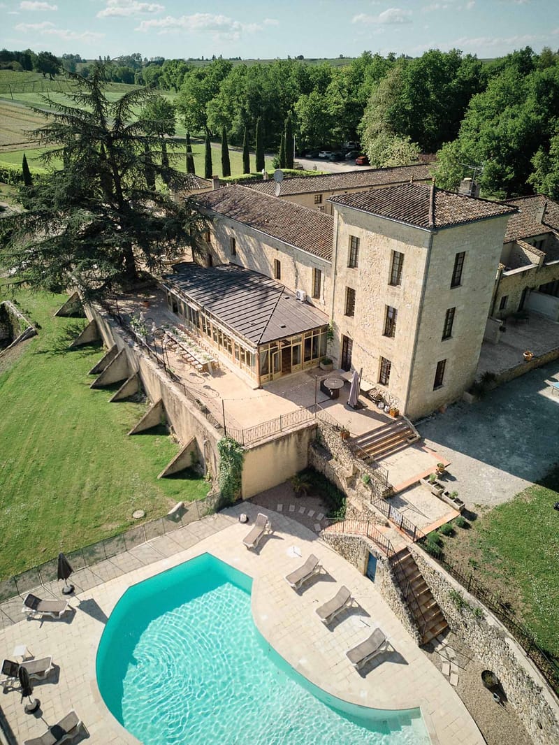 Aerial of Chateau de Sanse with pool and trees in spring Bordeaux