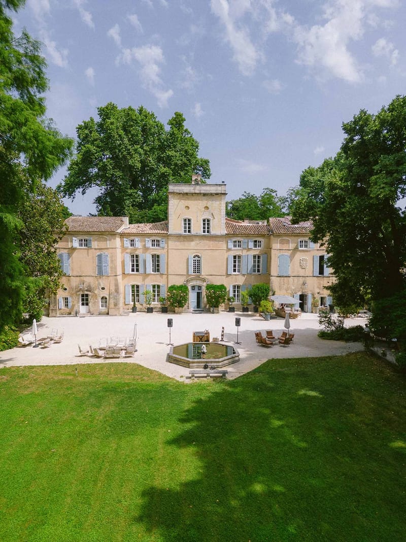 Aerial of Chateau des Barrenques with blue shutters and fountain Provence