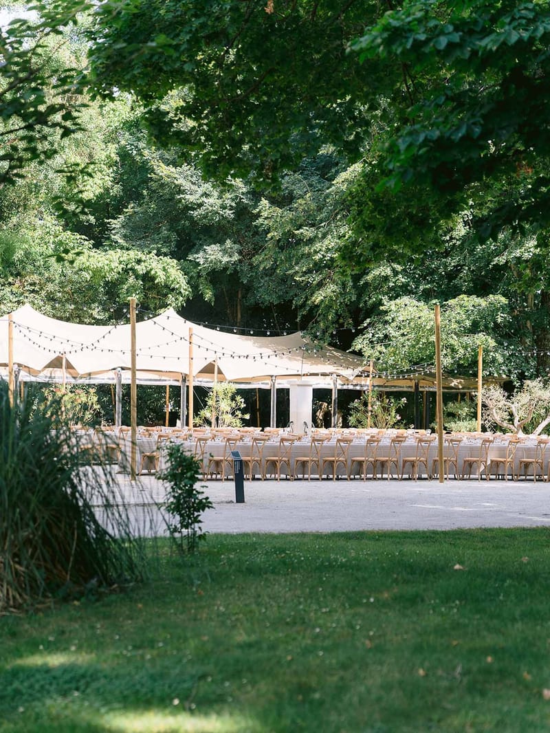 Reception marquee with festoon lights in garden at Chateau des Barrenques