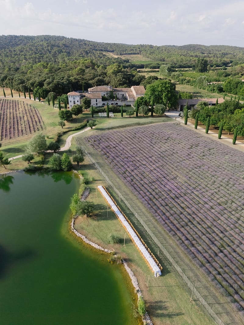 Aerial view of empty banquet table between pool and lavender at Les Domaines de Patras, Provence