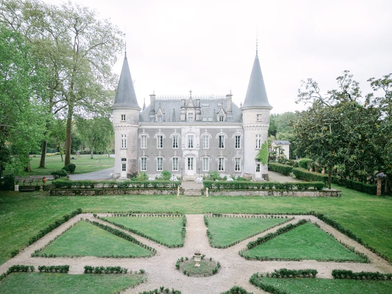 Grey stone chateau with conical turrets and parterre garden in symmetrical diamond boxwood pattern