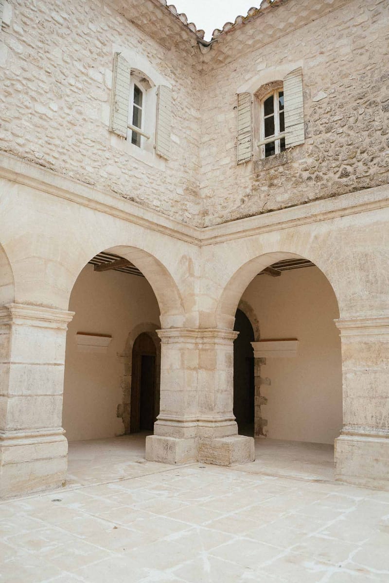 Stone courtyard with rounded arches carved pillars and covered arcade at historic French building