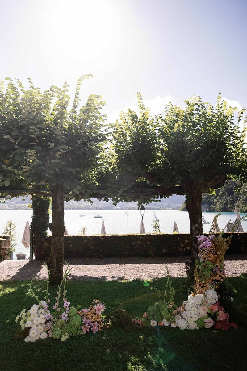 Ceremony arch with pleached trees and Lake Annecy view at Abbaye de Talloires