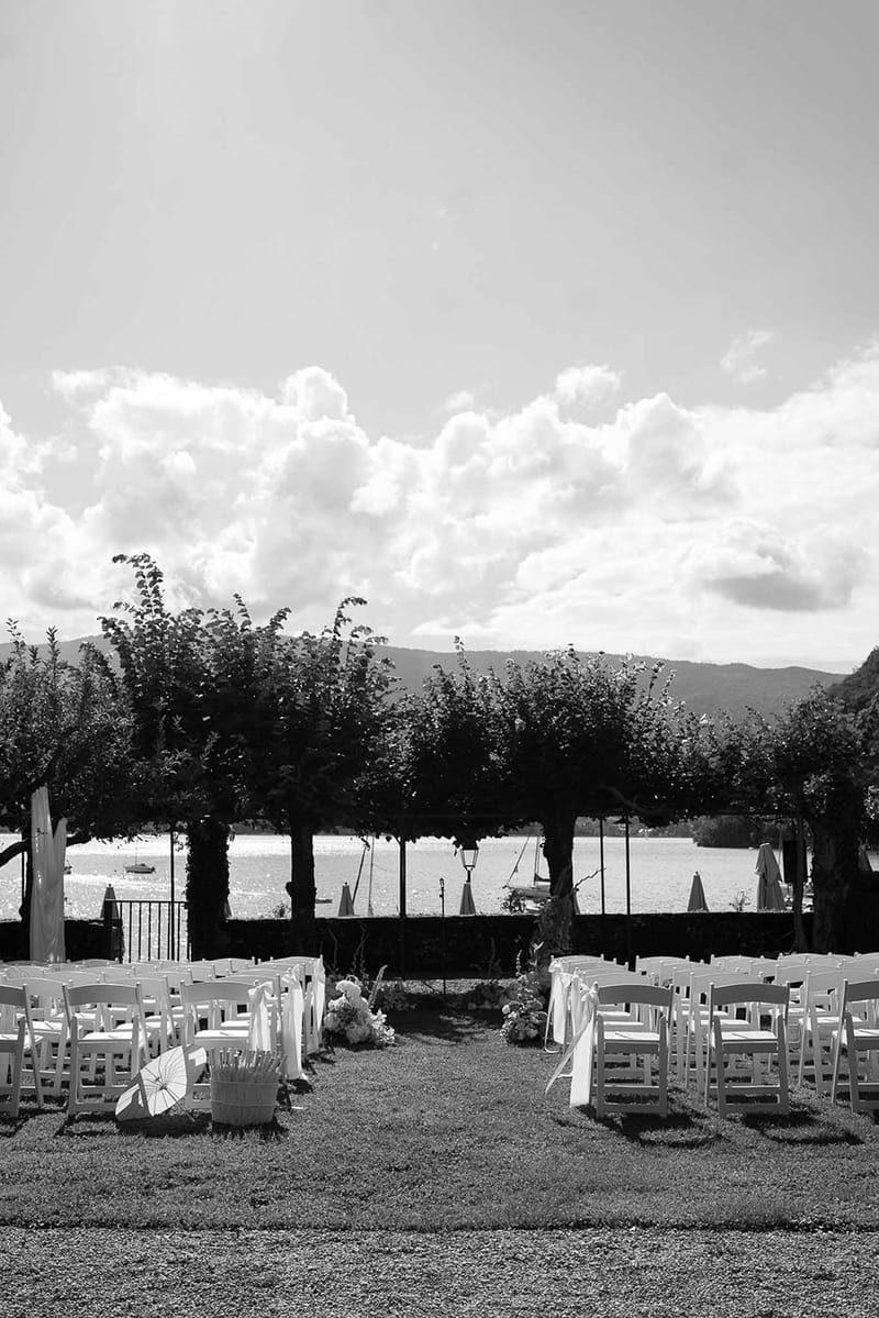 Ceremony setup from behind with tree altar and mountains in black and white at Abbaye de Talloires